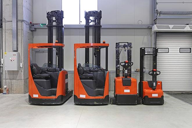 three forklifts parked in a warehouse